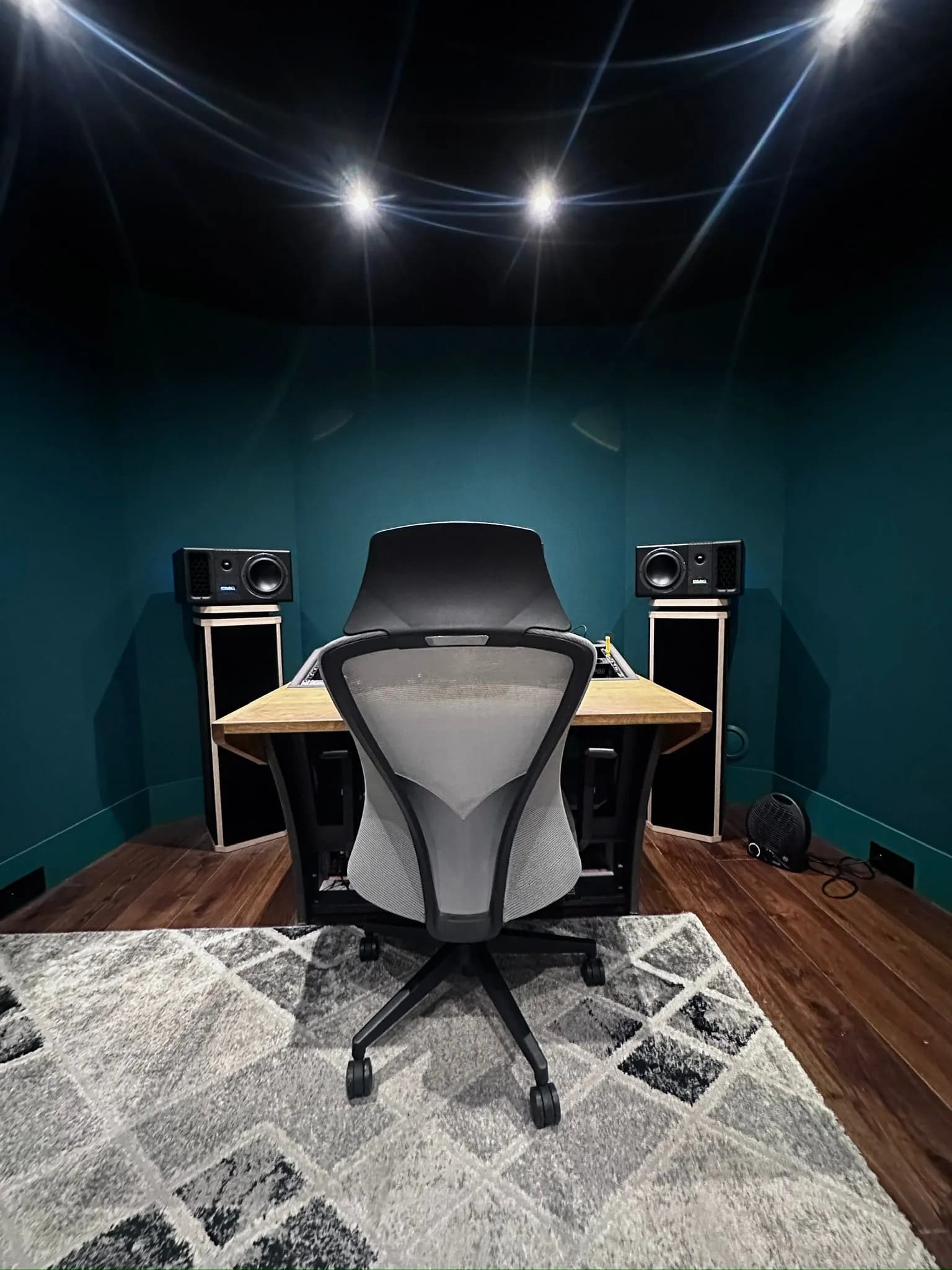 Régie de Coin Bleu Studio : poste de travail et enceintes de monitoring sous éclairage tamisé